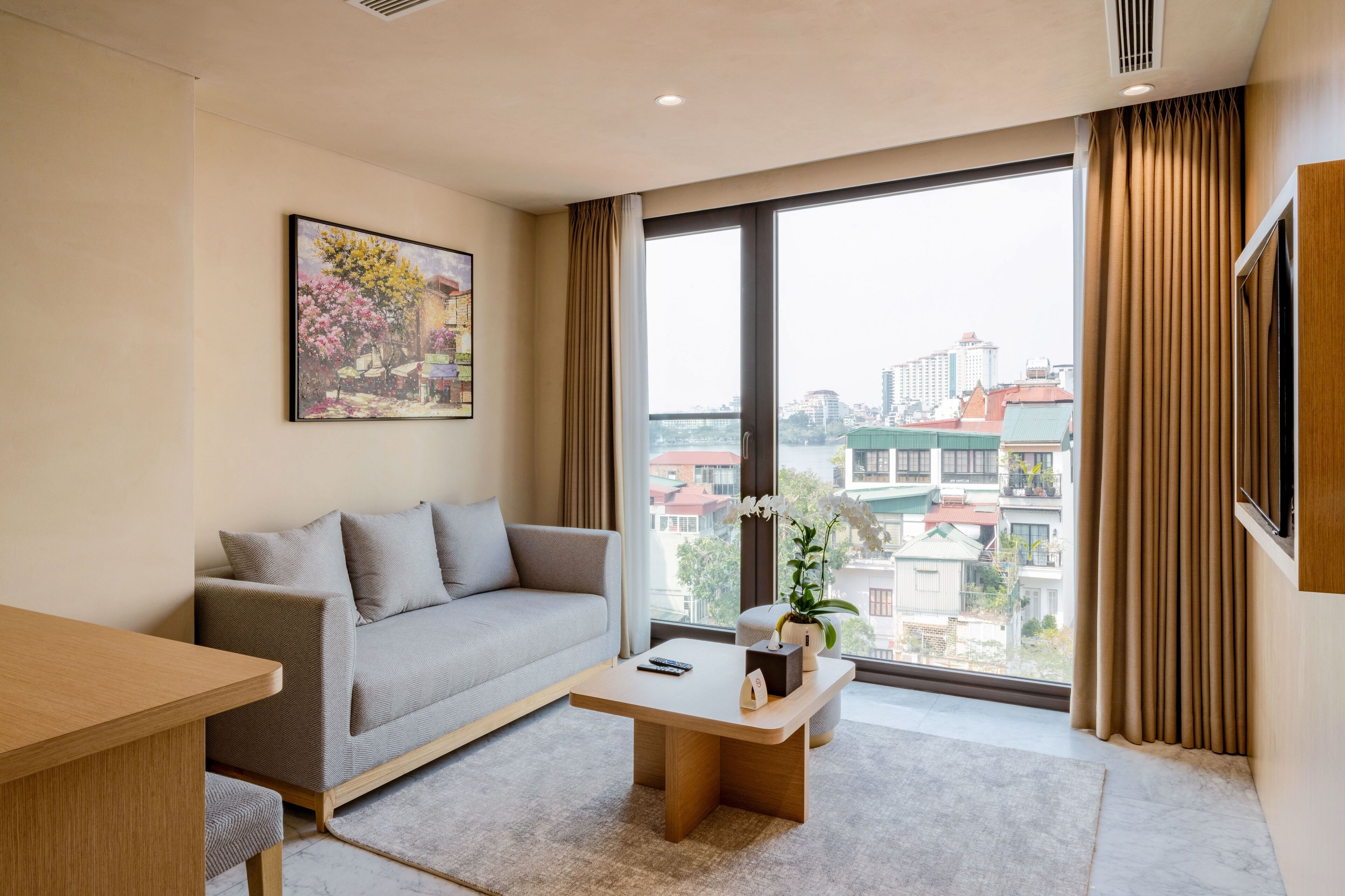 Una sala de estar moderna con un sofá, una mesa de centro y un cuadro en la pared.