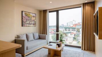 A modern living room with a sofa, coffee table, and a painting on the wall.