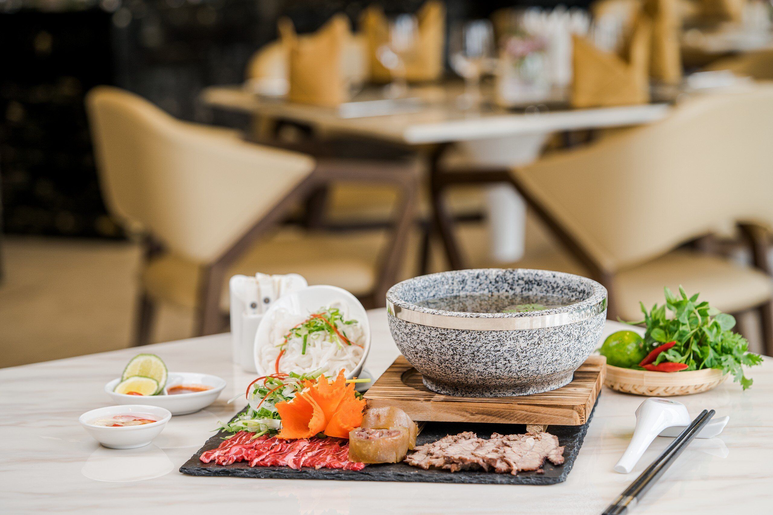 A dining table with a variety of dishes, including a bowl of soup, a plate of sliced meat, and a bowl of rice.