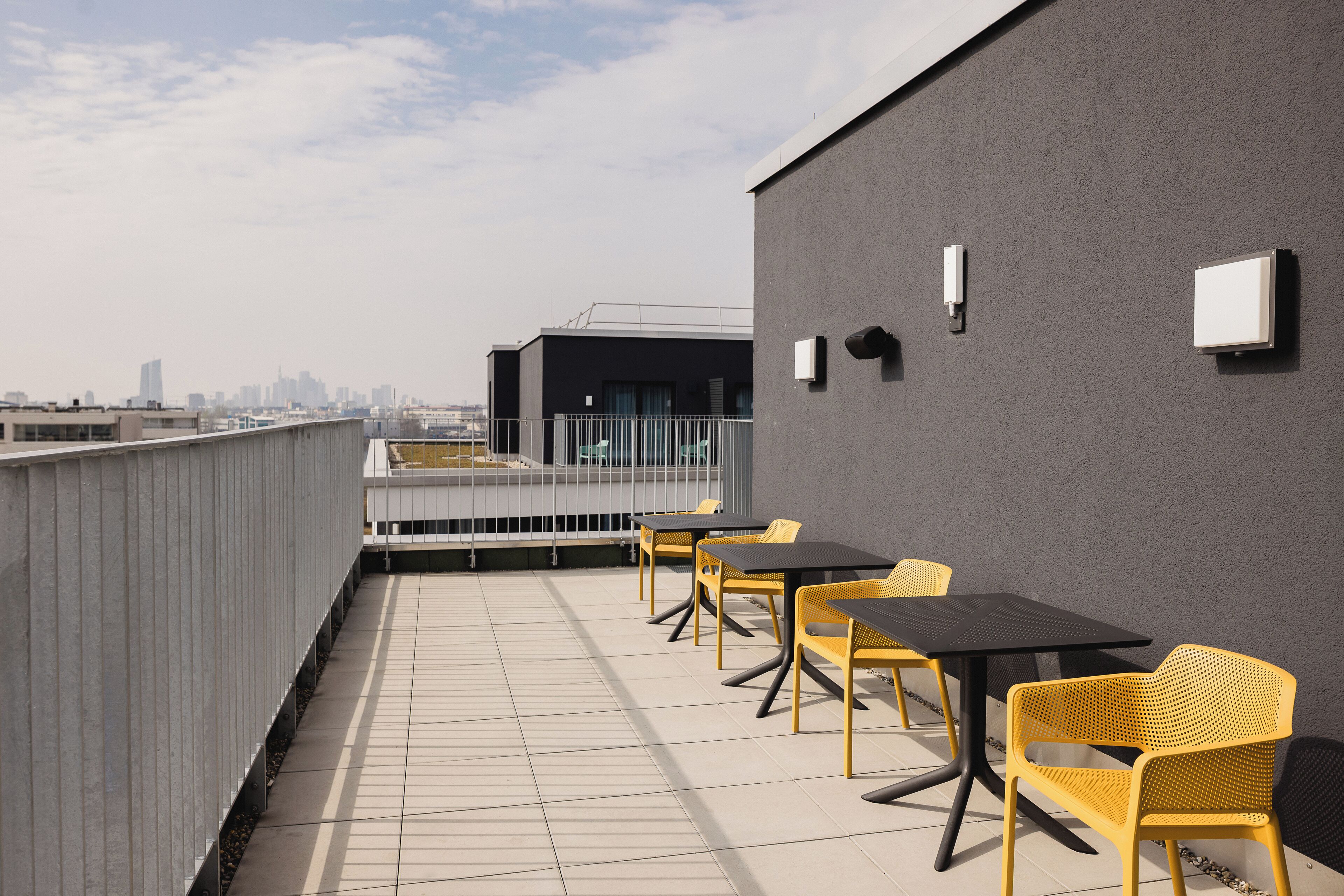 Eine Dachterrasse mit Sitzgelegenheiten und Blick auf die Stadt.