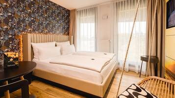 A hotel room with a bed, a desk, a chair, and a TV.