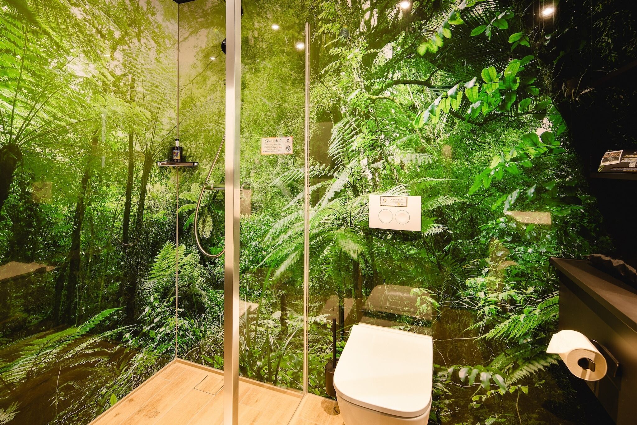 Un baño con cabina de vidrio, inodoro y lavamanos.