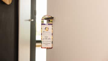 A door with a hanging sign that reads "Ríoca" and "não perturbe" with a translation "Do not disturb" and "Still dreaming of Rio...".