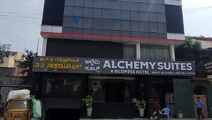 Un edificio con un cartel que indica 'Alchemy Suites', un hotel para negocios.