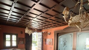 A cozy living room with a high ceiling, a chandelier, and a large window. - Hotel La Hoya del Tajo (Ronda)