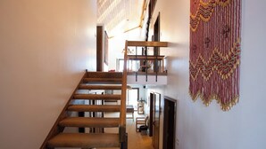 Una escalera de madera que sube a un rellano en el segundo piso.