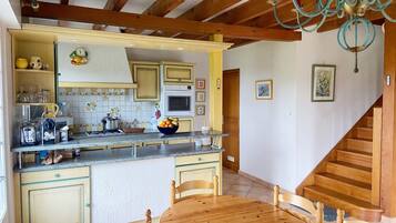 A kitchen with wooden cabinets, a central island, and a dining table with chairs.
