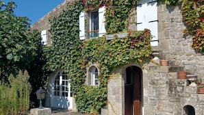 A stone building with ivy-covered walls, arched windows, and a small garden area with a lamp post. - KERDERFF - Holiday home for rent, between beach and forest, Carnac - TK30 (Carnac)