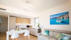 Un salon moderne avec un canapé et un coin repas comprenant une table et des chaises.
