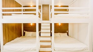 A bunk bed room with wooden headboards and wall-mounted lights. - Kiwi's Homestay & Cafe (Mui Ne)
