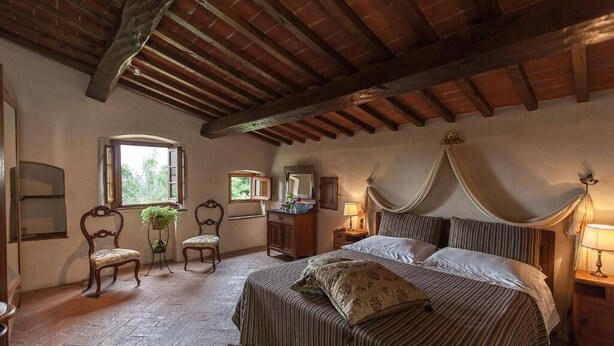 A bedroom with a large bed, wooden beams on the ceiling, a window, and a mirror. - Apartment in the tuscan countryside with pool (Sesto Fiorentino)