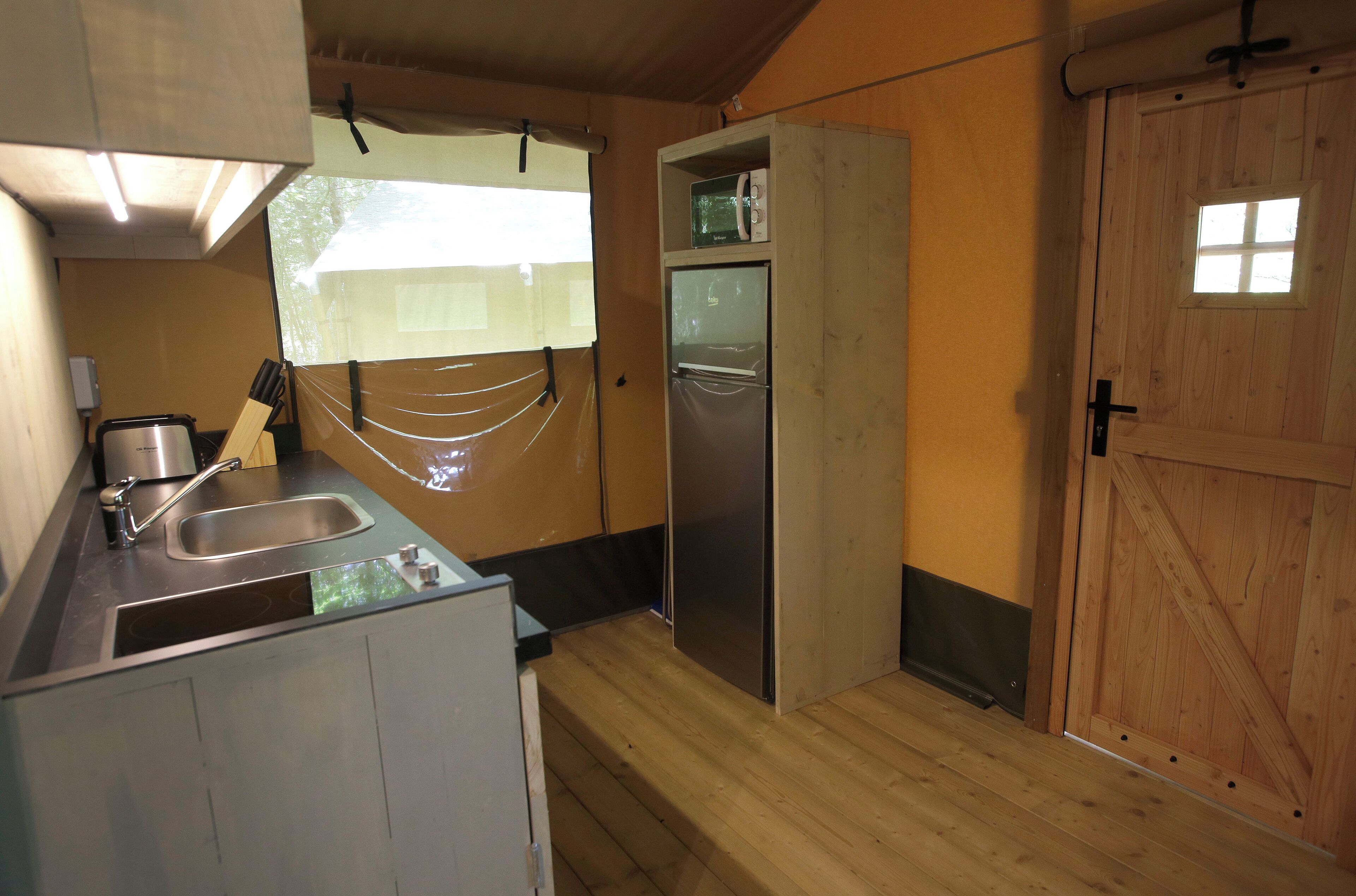 A compact kitchen with a sink, a microwave, and a refrigerator.