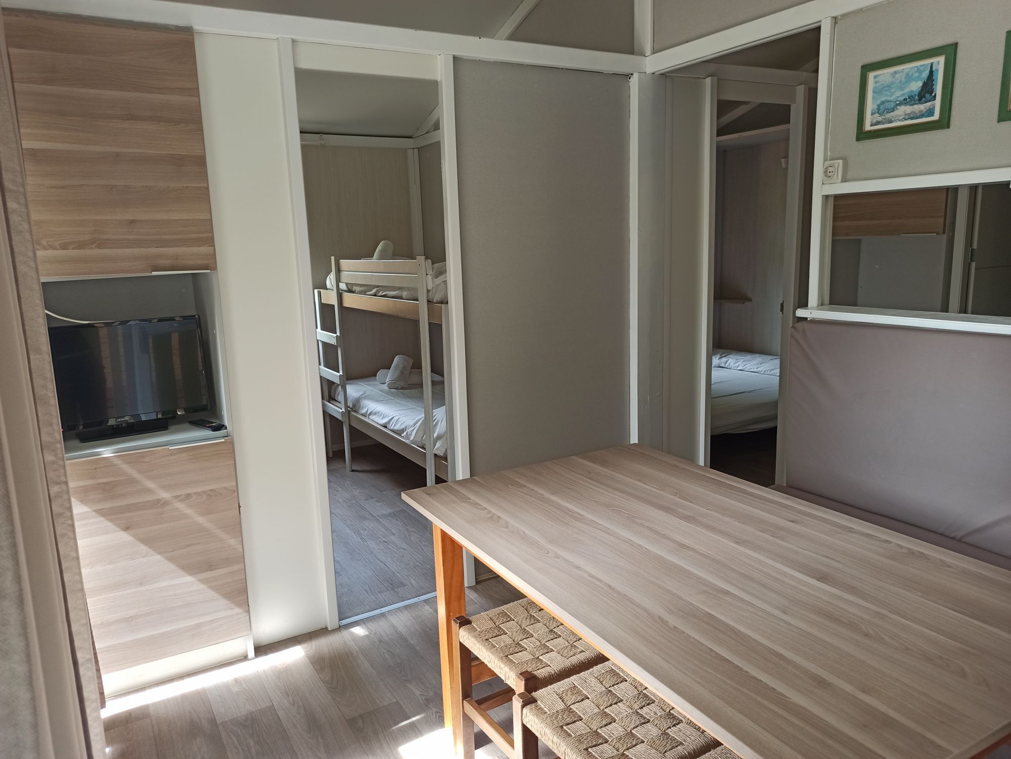 Een kleine kamer met een stapelbed, een bureau en een stoel.