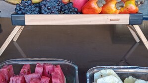Presentació de fruita amb pomes, plàtans i aranyons damunt d'un taulell de fusta.