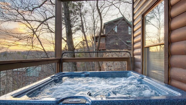 Un bain à remous avec vue sur une maison et des arbres.