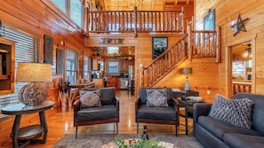 A cabin interior with a wooden interior, a dining area, a kitchen, and a staircase. - Misty Mountain by Avantstay Hot Tub, Mountain Views, Theater, Pool Table (Sevierville)
