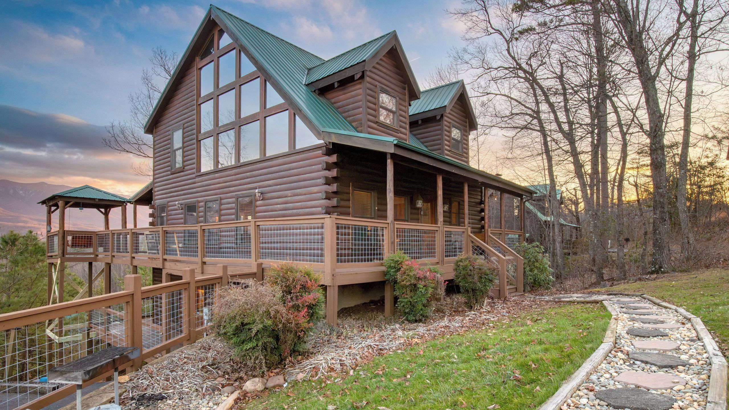 A log cabin with a balcony and a covered porch.