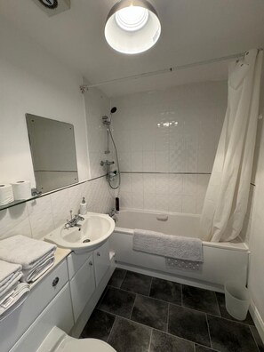 A modern bathroom with a white sink, mirror, and shower. - Home Sleeps5-netflix-parkg-near City Center/etihad (Manchester)