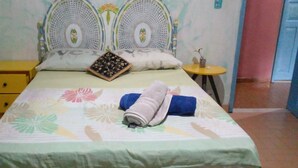 A neatly made bed with floral bedding, a small bedside table with a lamp, and a decorative headboard. - Casa da Piscina 3 bed House Near to the Beach (Saquarema)