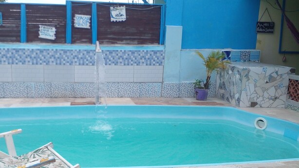 A swimming pool with a tiled wall and a blue and white tiled floor. - Casa da Piscina 3 bed House Near to the Beach (Saquarema)
