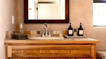 A bathroom with a wooden vanity, a sink, and a mirror.