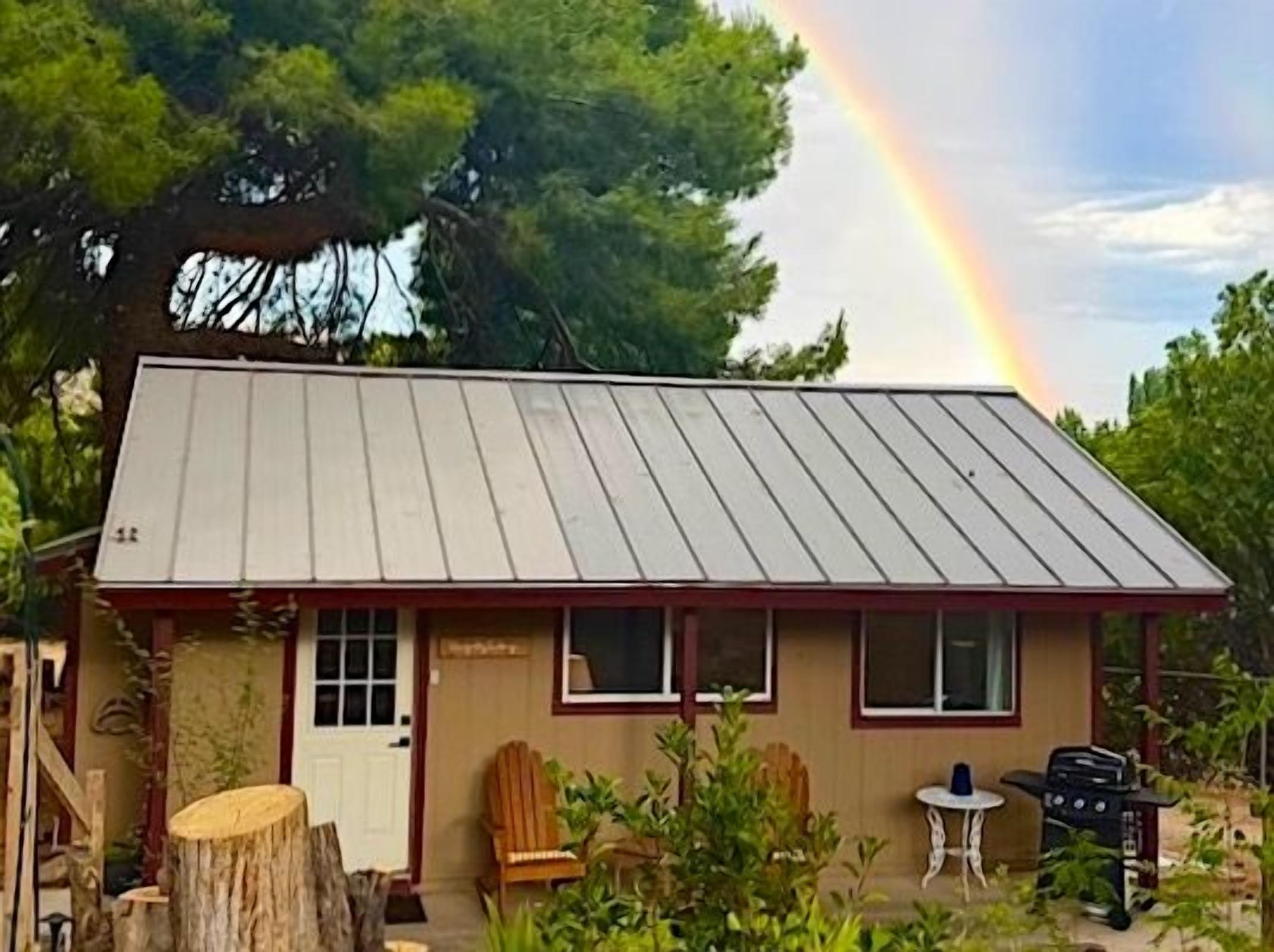 A single-story building with a metal roof, a front door, and windows.