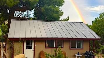 A single-story building with a metal roof, a front door, and windows.