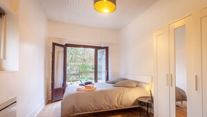 Une chambre à coucher avec un lit, une table de chevet, une lampe et une armoire.