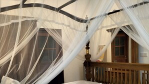 A bed with a canopy, pillows, and a wooden headboard. - Charika Villa (Bentota)