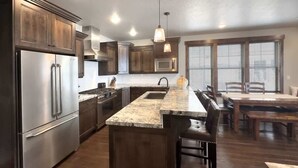 Una cocina moderna con una isla grande, electrodomésticos de acero inoxidable y armarios de madera.
