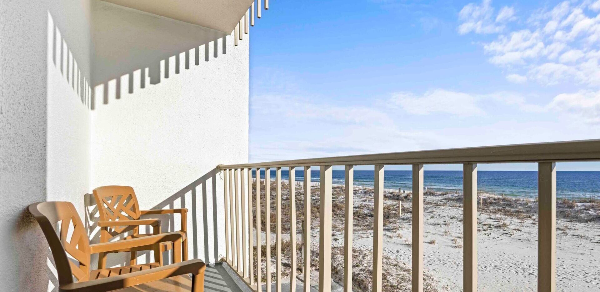 A balcony with a view of a beach and ocean.
