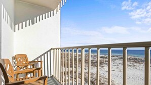 A balcony with a view of a beach and ocean.