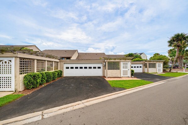A residential property with a garage, a well-maintained lawn, and a clear sky.