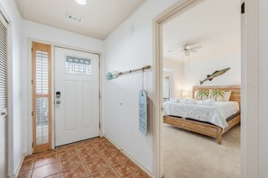 Un dormitorio con cama, ventilador de techo y un adorno de pez en la pared.