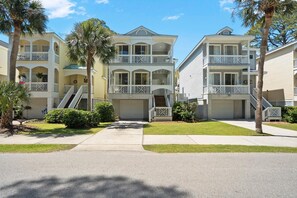 A row of two-story beachfront condos with balconies, a central walkway, and a palm tree-lined street. - 728 Bonito Road (Fripp Island)