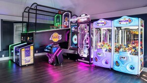 A row of arcade machines, including basketball and claw games, with a basketball hoop and a display of NBA Lakers memorabilia. - 180 Beach Club Villa (Fripp Island)