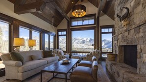 A spacious living room with a fireplace, large windows offering mountain views, and a cozy seating area. - 23 Powder Ridge - Managed by Purgatory Resort (Durango)