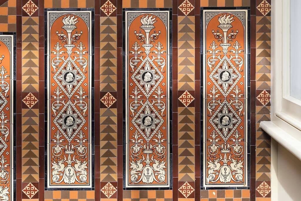 A wall with decorative tiles featuring geometric patterns and a central emblem.