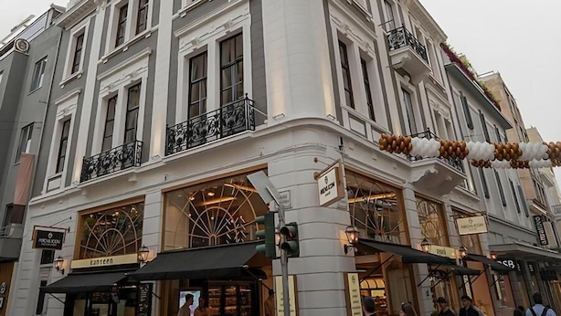 A corner building with multiple storefronts, including a visible restaurant and a shop with a sign that reads "kanreen."