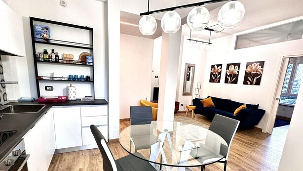 A modern kitchen with a dining area, a sofa, and a coffee table.
