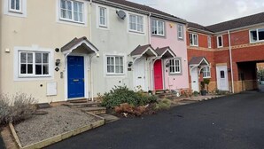 A row of terraced houses with distinct front doors, each with a different color.