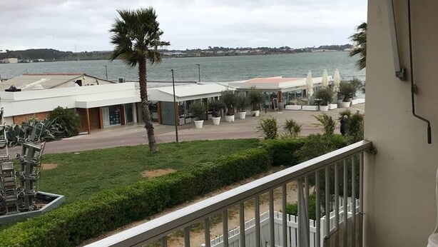 Ein Balkon mit Blick auf einen Strand und das Meer.