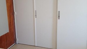 Eine weiße, geschlossene Tür mit silbernem Griff und einem hölzernen Türrahmen.