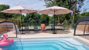 A swimming pool with lounge chairs and umbrellas, surrounded by a fence and trees. - Spacious house, private pool - 11 guests (La Flèche)
