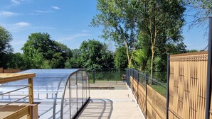 A covered outdoor area with a wooden bench, a glass enclosure, and a fence. - Spacious house, private pool - 11 guests (La Flèche)