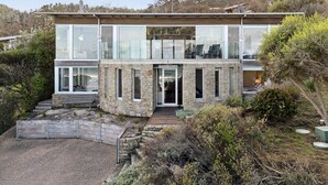 Un edificio de dos pisos de piedra con fachada de vidrio, una entrada visible y un letrero que dice 'SANDBANKS'.