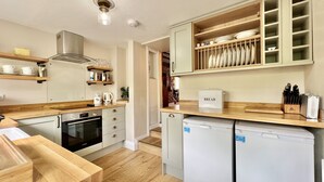 Una cocina moderna con encimeras de madera, un lavavajillas Bosch y un horno empotrado.