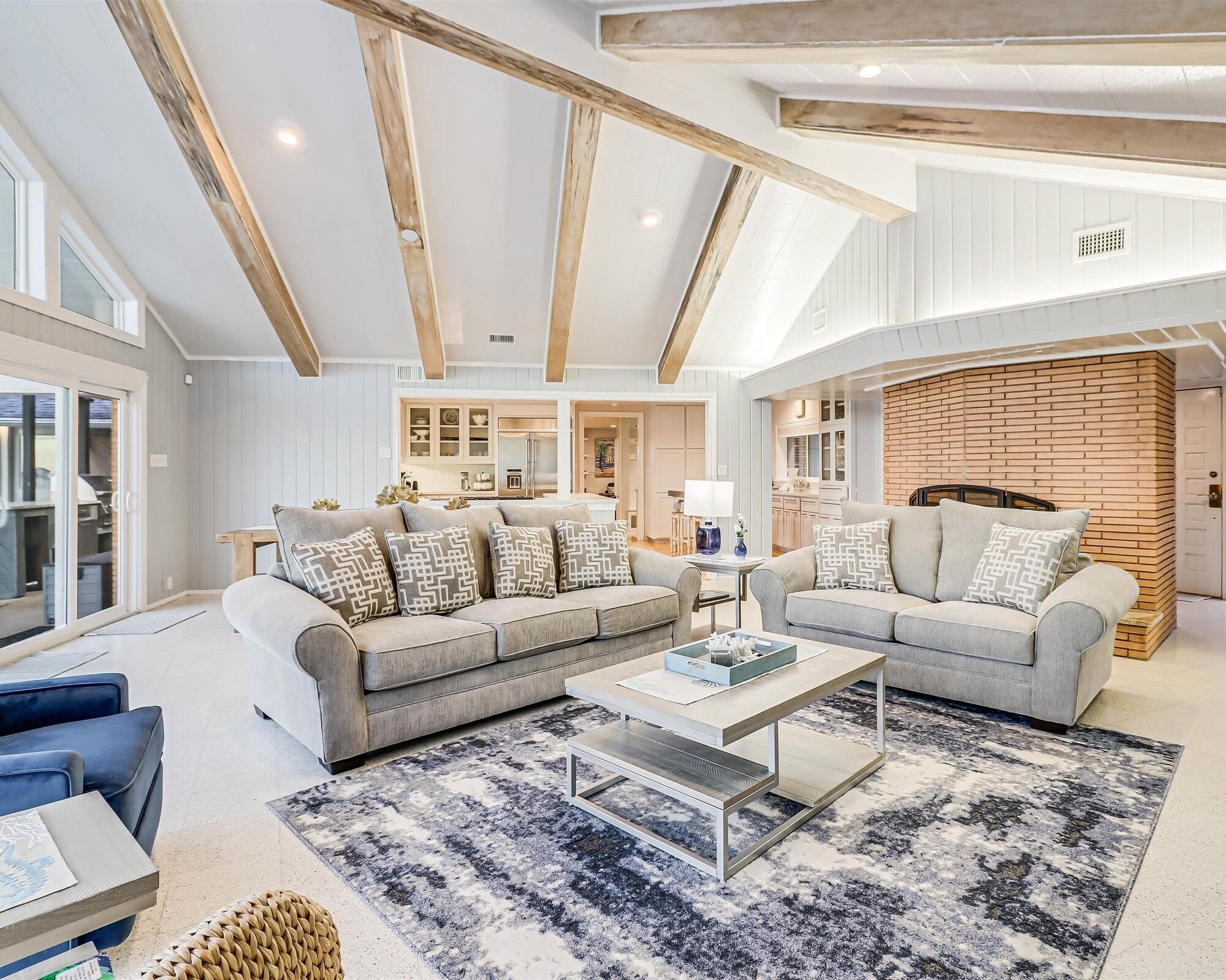 A spacious living room with two sofas, a coffee table, and a patterned rug.