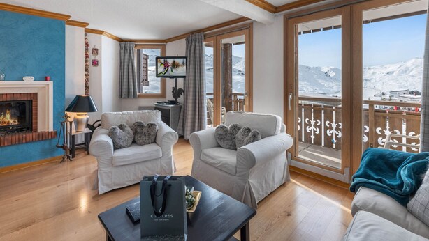 Ein gemütliches Wohnzimmer mit Kamin, zwei Sofas, einem Couchtisch und einem Fernseher.