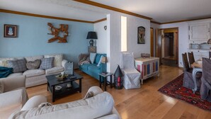 Ein geräumiges Wohnzimmer mit einer Couch, einem Couchtisch und einem Essbereich mit Tisch und Stühlen.